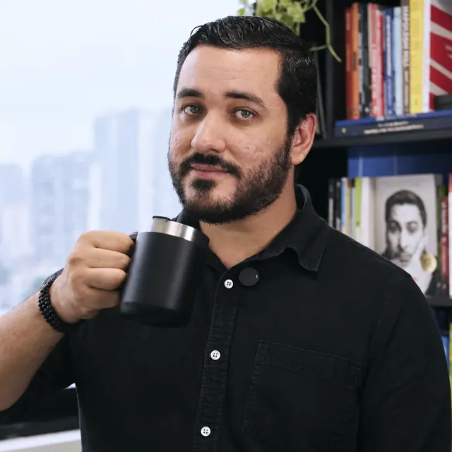 Marco Biazon segurando uma caneca no escritório da Pulso